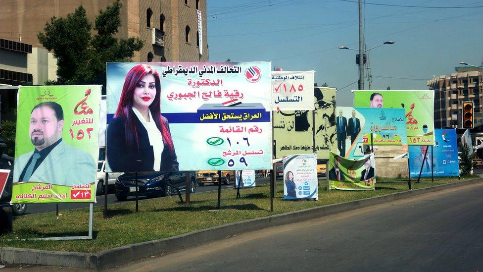 Election posters featuring men and women are seen in Baghdad, Iraq, on 19 April