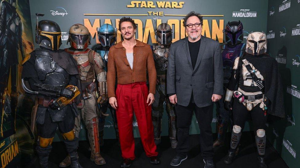 Pedro Pacal and Jon Favreau pose with actors in Mandalorian armour in London.