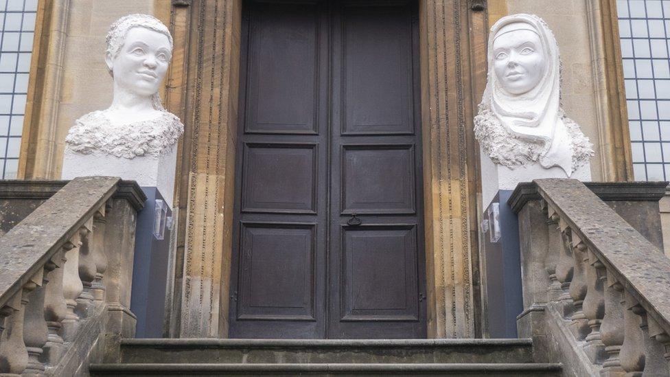 Two sculptures on plinths at the entrance