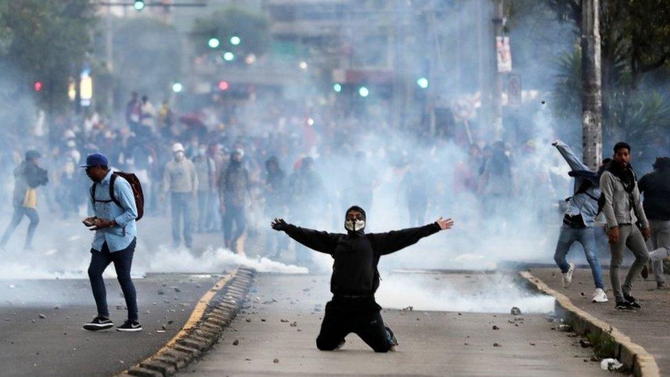 A protester knells in the street during demonstrations against cuts to fuel subsidies