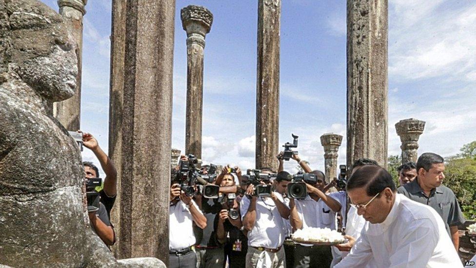 Sri Lankan President Maithripala Sirisena offers flowers at a temple (05 June 2015)