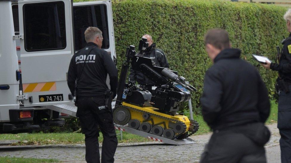 Police officers are seen as Peter Madsen (not pictured) is surrounded by the police in Albertslund, Denmark October 20, 2020