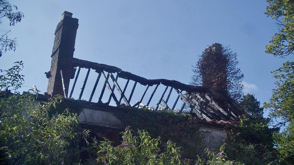 The burnt roof of a derelict house