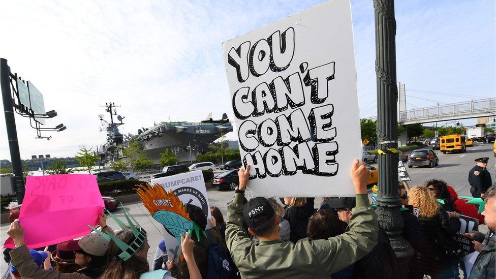 Protesters gather near the USS Intrepid, a decommissioned World War II aircraft-carrier now the Intrepid Sea, Air and Space Museum, to protest against US President Trump May 4, 2017 on the Hudson River in New York.