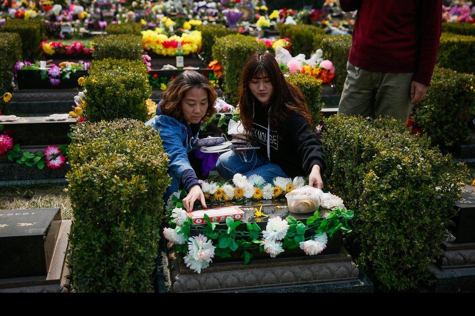 A Chinese family visits the gravesite of their deceased relatives to mark the Qingming Festival at the Changqingyuan cemetery in Beijing, China, 3 April 2017.