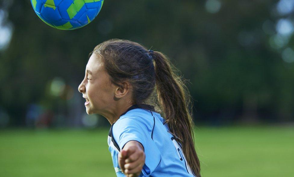 girl heading a football