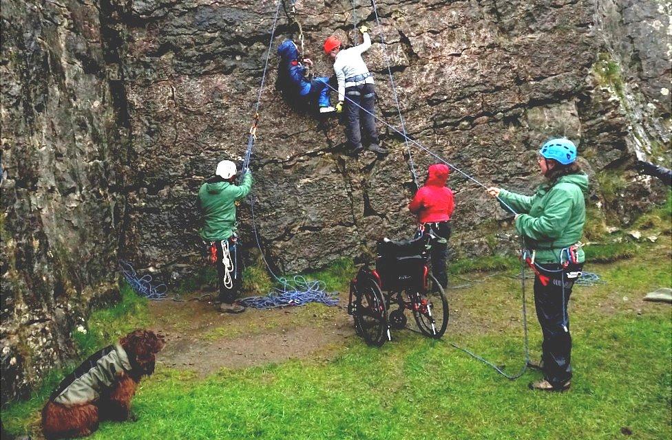 Chris and Vicky helping Chloe to climb the rock