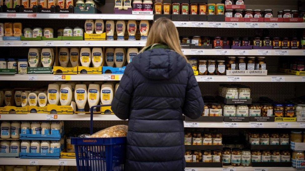 Woman looking at supermarket shelves