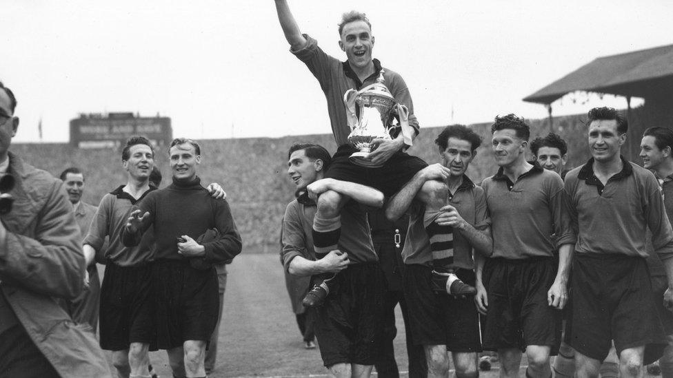 Billy Wright held aloft by his teammates