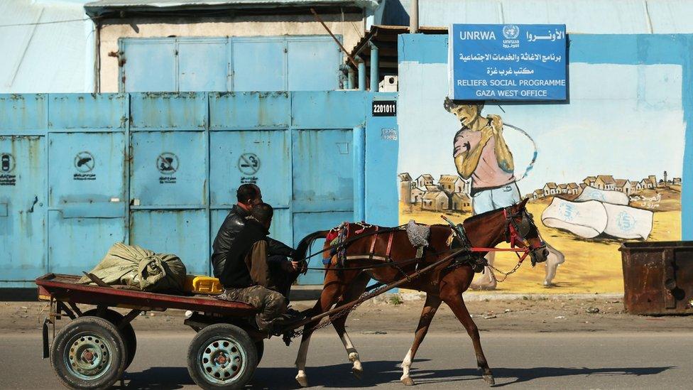 A Palestinian man rides a horse and car past an Unrwa office in Gaza City on 8 January 2018