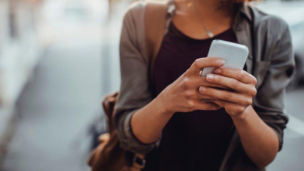 A woman holding a phone