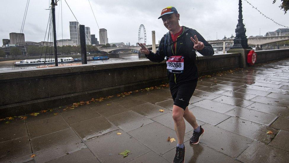 A runner wearing a London Marathon running number on the Embankment in central London