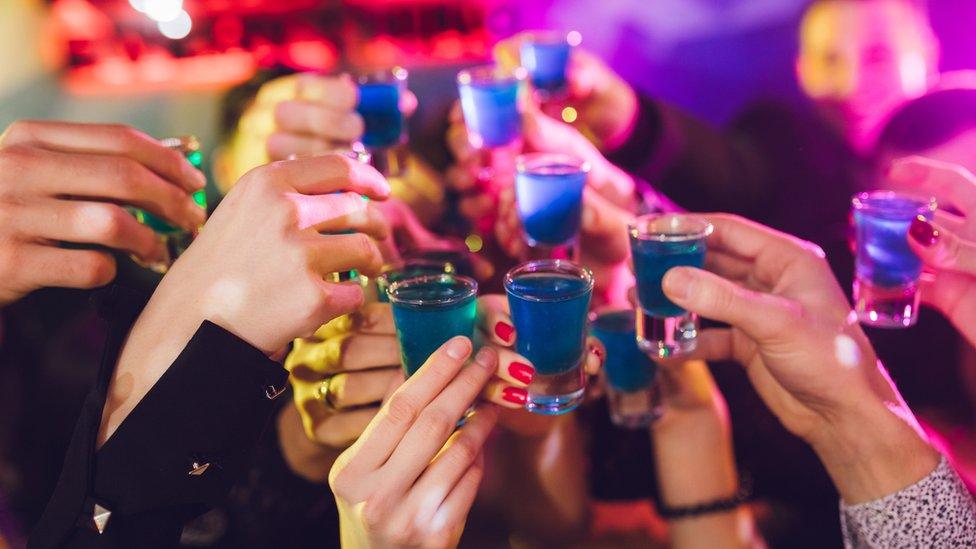 Women holding shot glasses