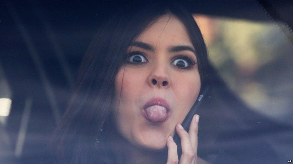 In this Tuesday, April 28, 2015 photo, Miss Universe Paulina Vega, from Colombia, jokingly sticks her tongue out at photographers from a car after visiting patients at a military hospital in Bogota, Colombia. Vega is in her native country for her first official visit since she was crowned Miss Universe in January.