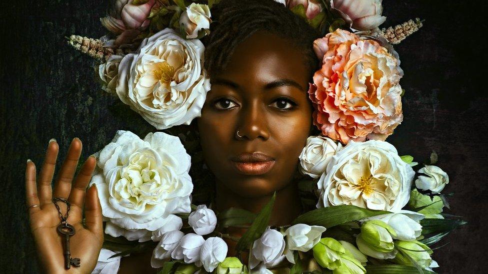 Portrait by Alanna Airitam showing a woman with a floral headdress