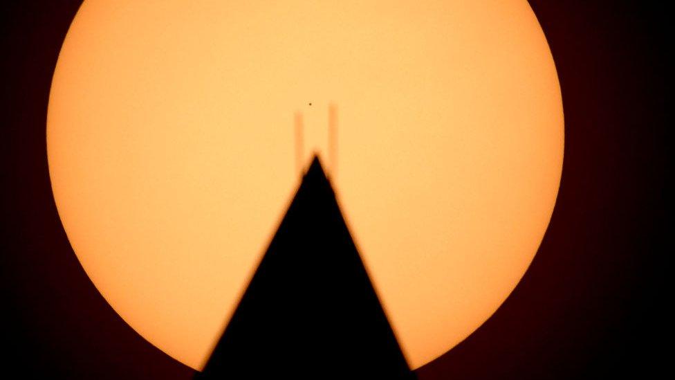 Mercury situated in the centre of the Sun just above a memorial in Washington DC, USA