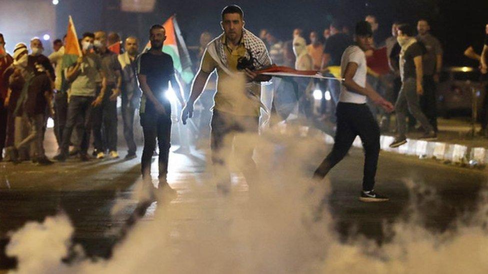 Palestinian holds flag during a demonstration