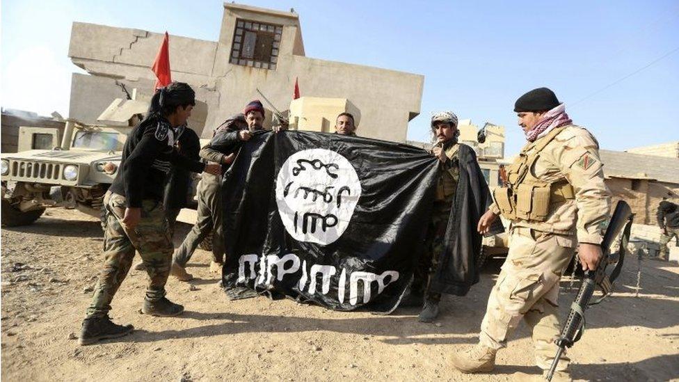 Iraqi soldiers hold IS flag captured in village outside Mosul (29/11/16)