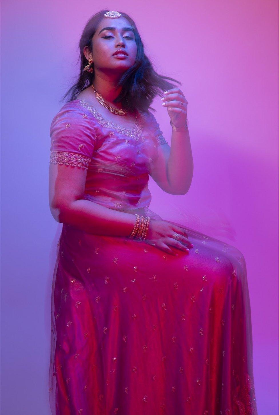 A portrait of a woman wearing a dress with a blurred effect implying movement