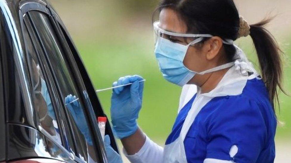 Nurse testing someone at a drive-thru test centre