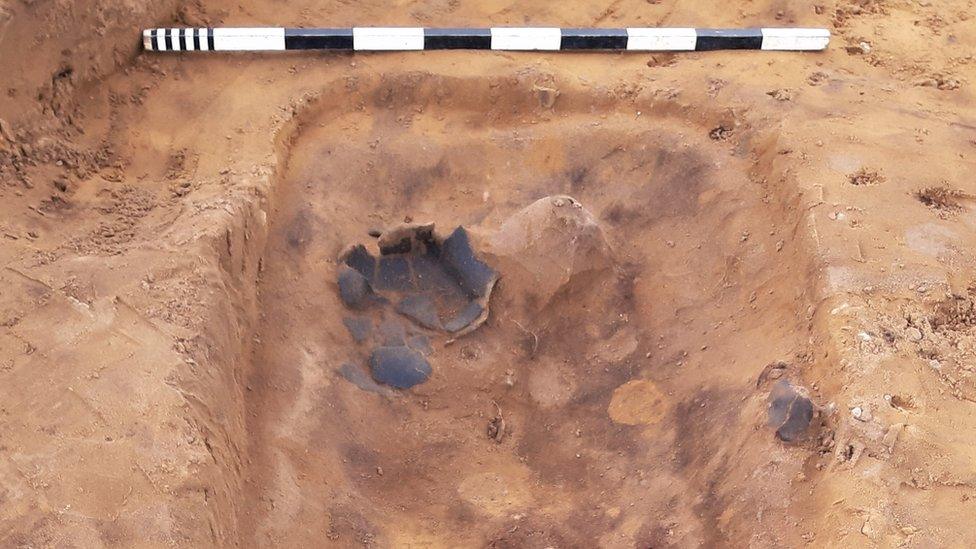 A pot placed by the head of a skeleton at the Anglo-Saxon cemetery at Oulton