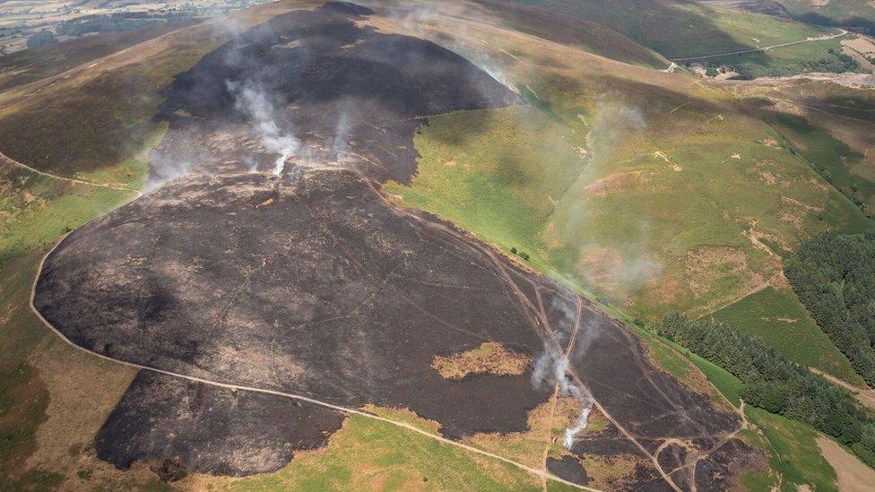 Aerial shot smouldering landscape caused by a wildfire on Llantysilio Mountain in Llangollen