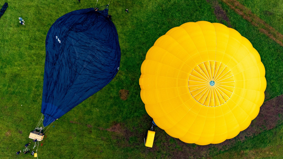 Two hot air balloon canopies on the grass