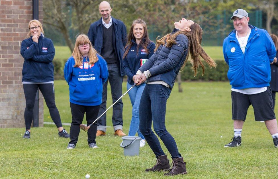 Kate laughs as she plays golf