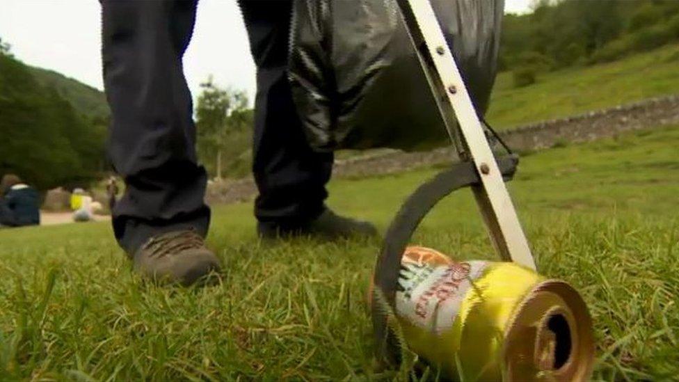 A warden picks up a can