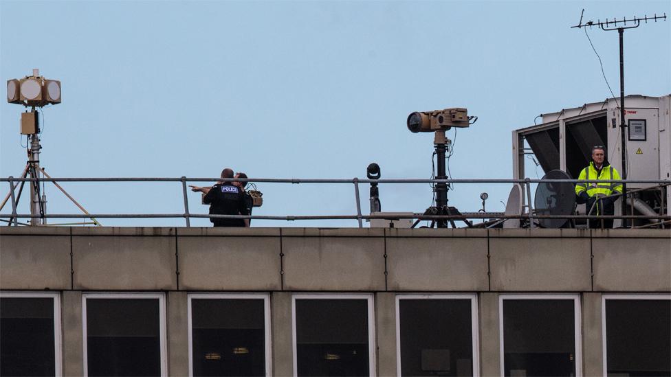 Police and security personnel on the roof of a building at Gatwick Airport on December 21