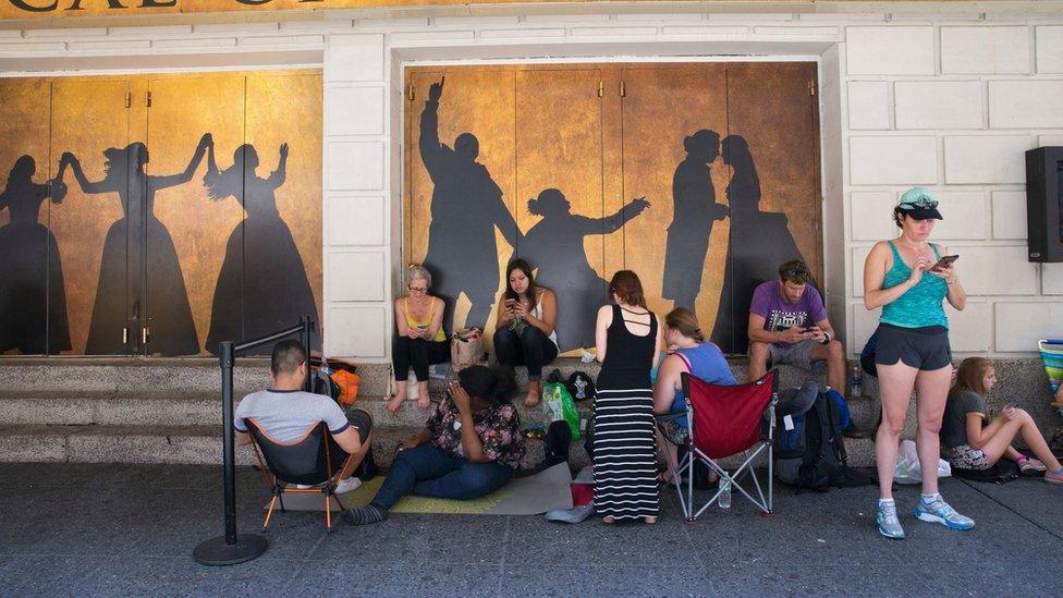 People wait in line outside the Richard Rodgers Theatre in hopes of buying tickets for the Tony Award-winning musical Hamilton on 8 July