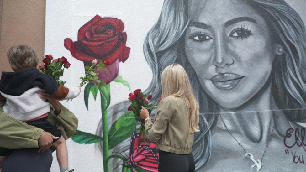 Elle's loved ones lay flowers at the mural