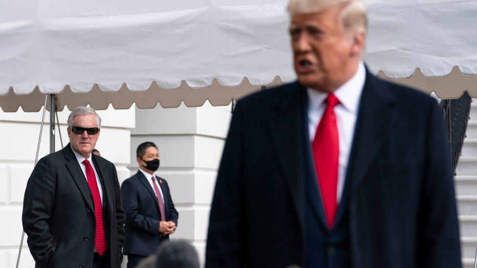 Meadows (left) seen looking on as Trump speaks to the media