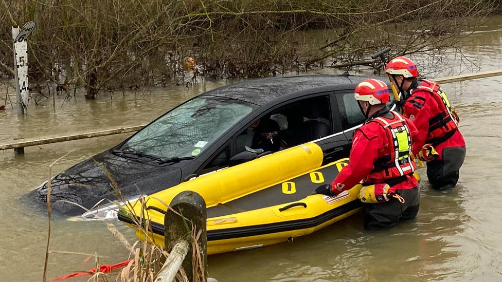 Firefighters and a car in the water at Buttsbury Wash near Billericay in Essex