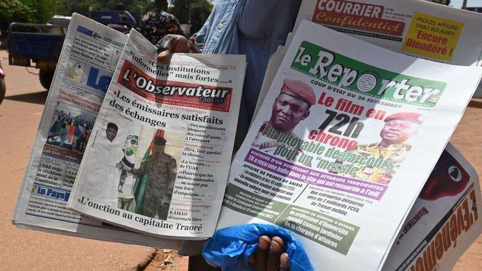 A street vendor sells local newspapers in Ouagadougou on October 5, 2022 which headline the September 30 military coup