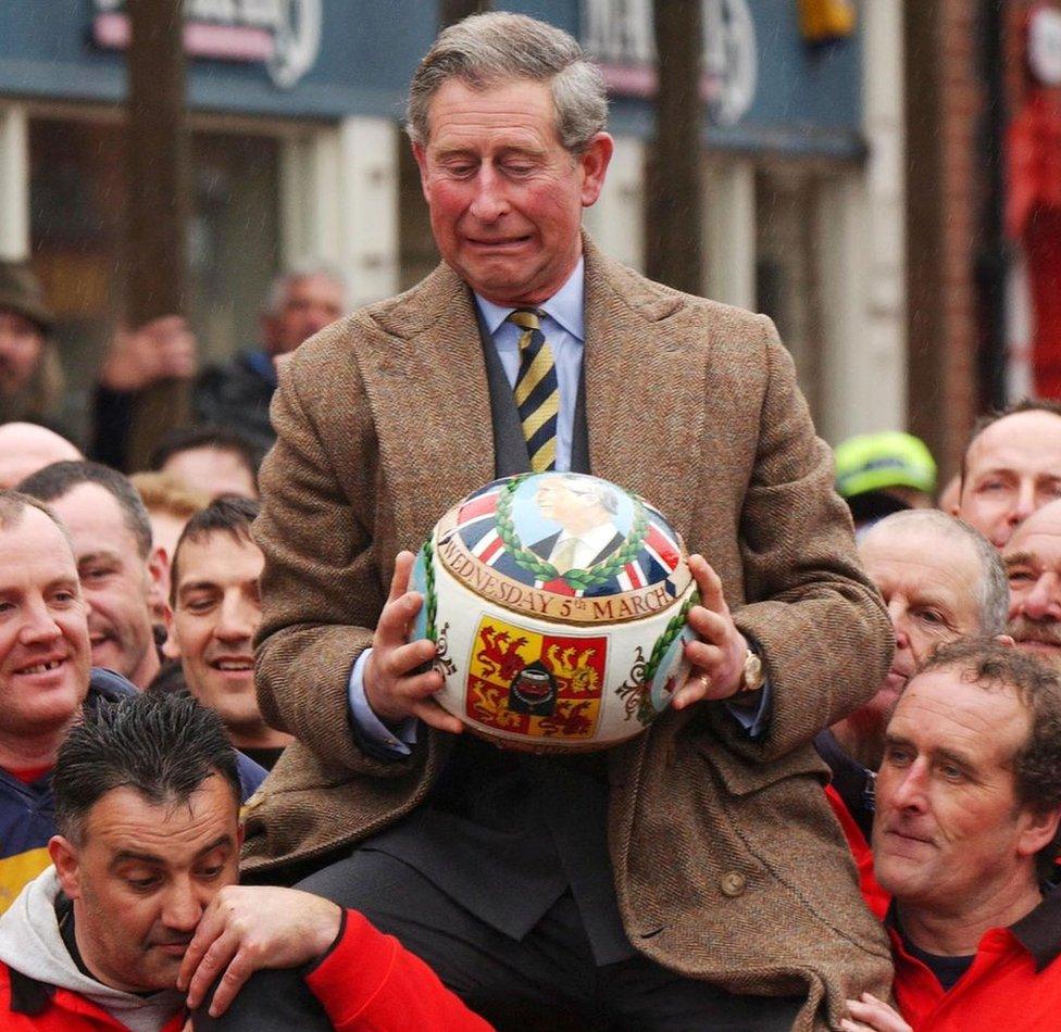 Prince Charles being lifted up holding the ceremonial ball before starting the ancient Royal Shrovetide Football game, in Ashbourne, Derbyshire