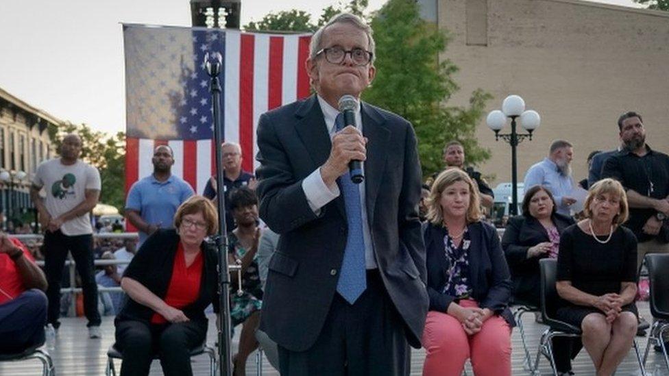 Ohio Governor Mike DeWine reacts as vigil attendees shout "DO something" while he was speaking at a vigil at the scene after a mass shooting in Dayton