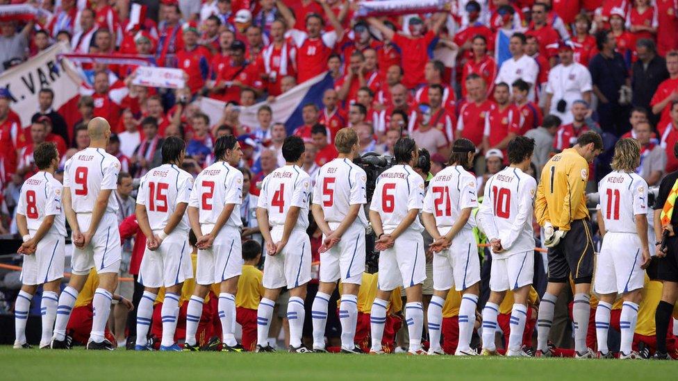 Czech footballers and their fans stand for the national anthem