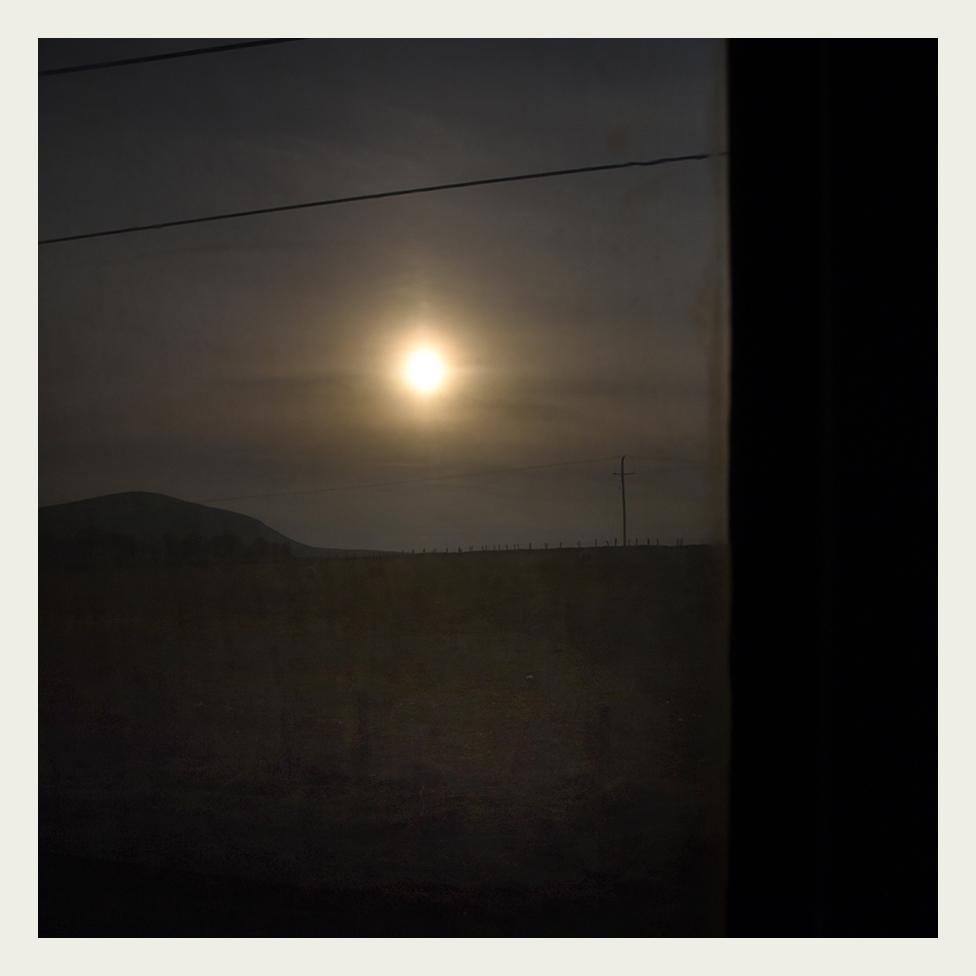 Evening sun is seen through the grubby window of a locomotive