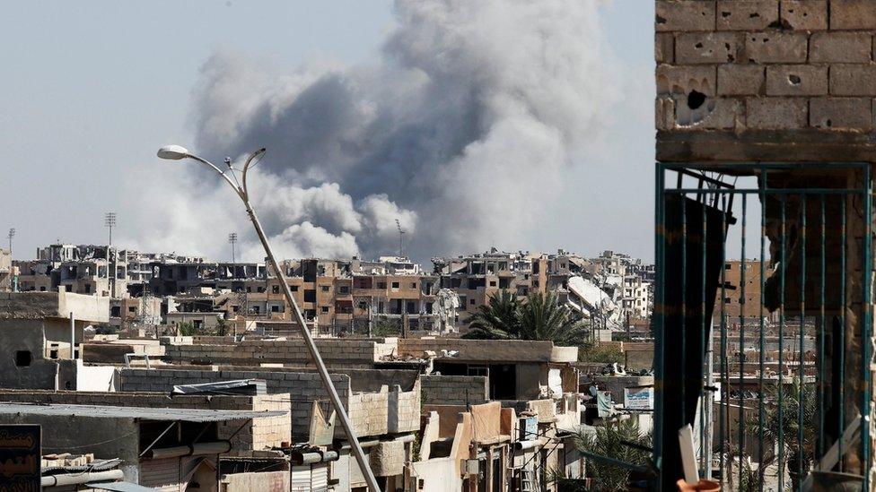 Smoke rises near the stadium where the Islamic State militants are holed up after an air strike by coalition forces at the frontline, in Raqqa