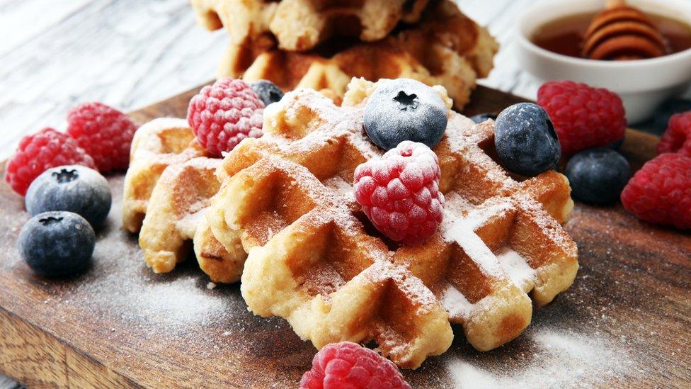 Traditional belgian waffles with fresh blueberries, sugar and raspberries