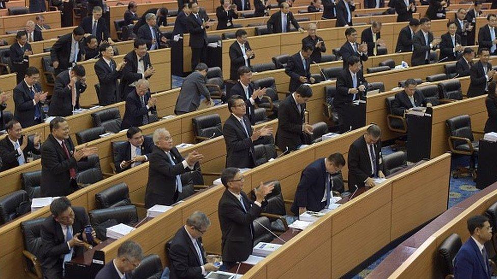 Members of the Thai National Reform Council (NRC) applaud after the vote for the draft of the new constitution at Parliament in Bangkok on September 6, 2015