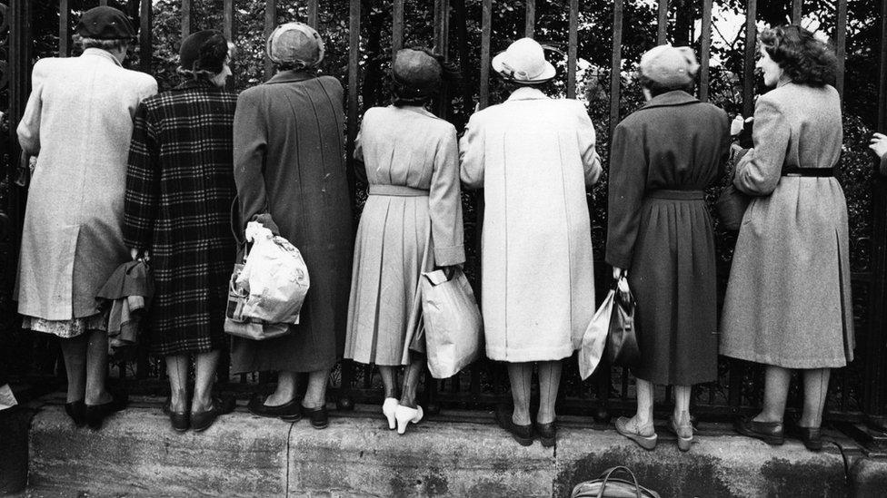 A group of women peer through the railings during a Royal trip to Edinburgh.