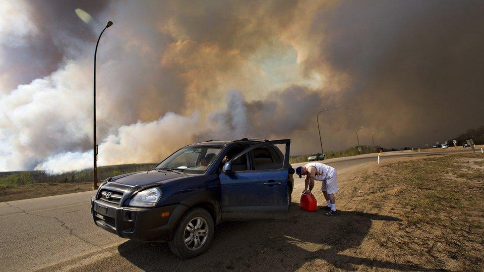 Resident putting gas in his car outside of Fort McMurray