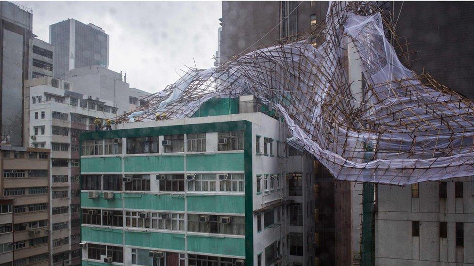 Rescue workers attempt to secure collapsed bamboo scaffolding on the top of a tall building in Hong Kong on 2 August 2016.