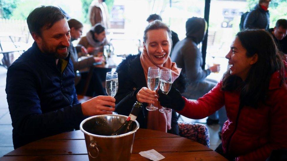 People toasting in a pub in London on 12 April