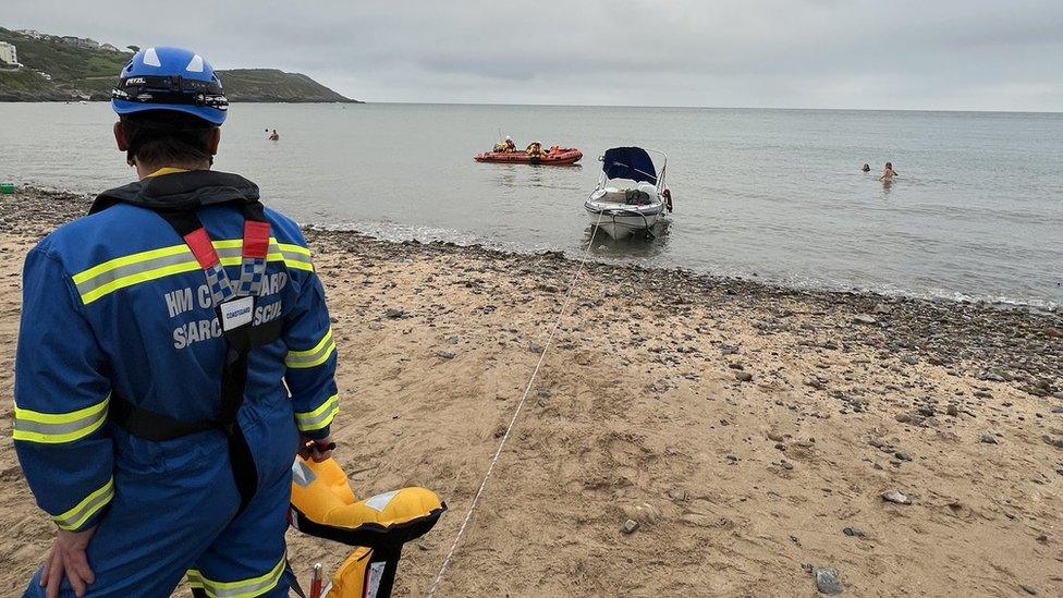 rescuers pulling boat ashore