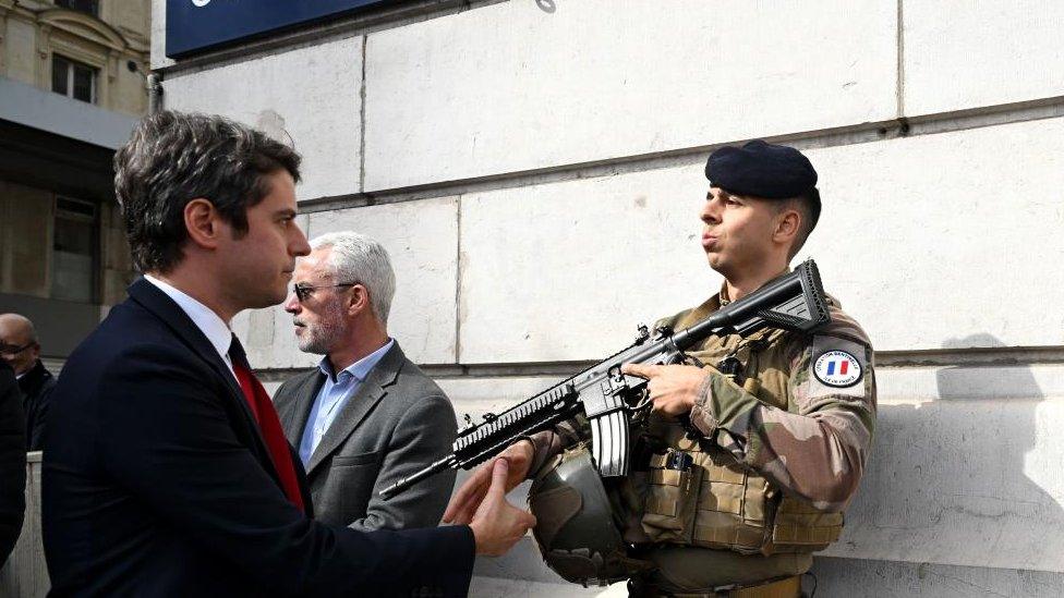 French Prime Minister Gabriel Attal (L) greets a French soldier of the Sentinelle security operation during a visit to the Saint-Lazare railway station in Paris, France, 25 March 2024