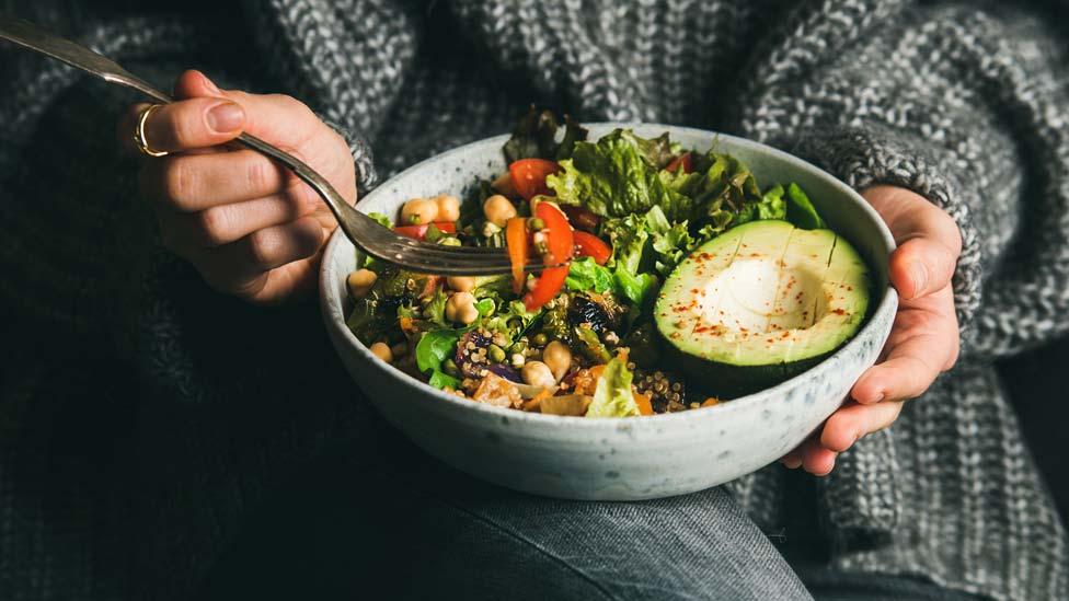 Young woman holding a bowl of food