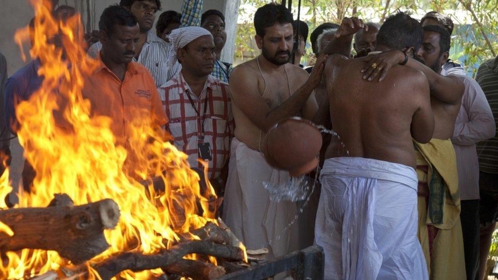 The victim's father, Madhusudhan Rao, performs rituals around his son's body